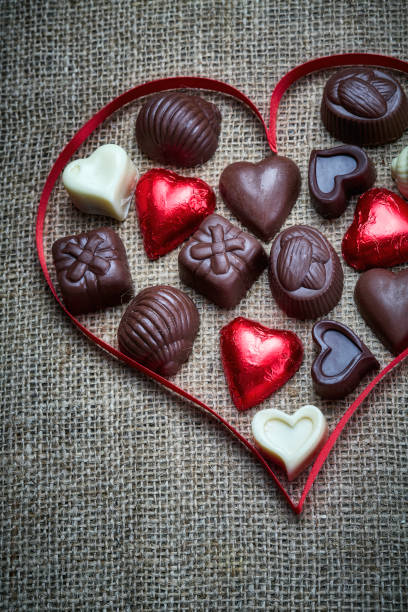 istock Valentine's Day theme: Chocolate candies in heart shape on a rustic table 1296850552