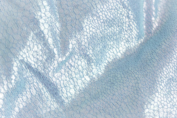 istock Creased textile texture, background template. Shine fabric light blue drapery. Sheene sharkskin fabrics for fashion dress. 1296854252