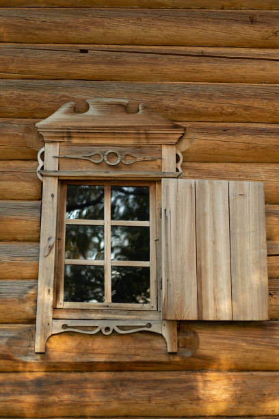 istock An old window with platbands on the background of a log wall. 1296855594
