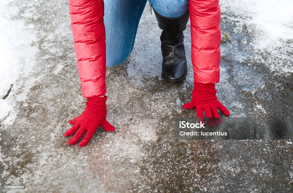 Woman slipping on icy street in winter. Unrecognizable woman slipping on icy street in winter. Falling Stock Photo
