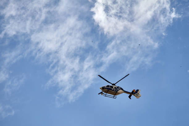 A Police helicopter flying in the cloudy blue sky over Madrid