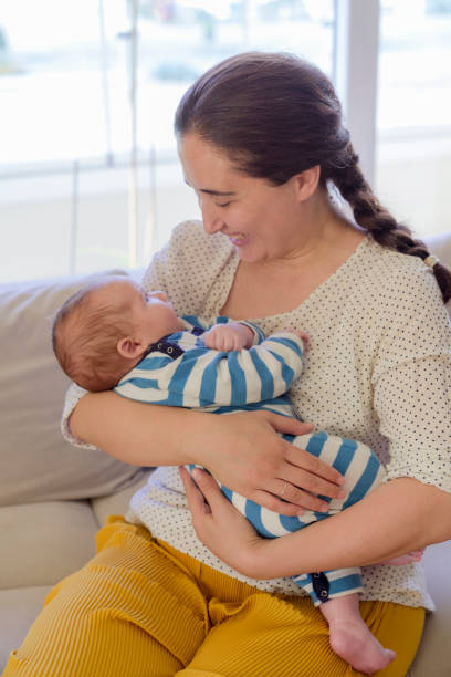istock Mother playing with her baby on the sofa 1296863941