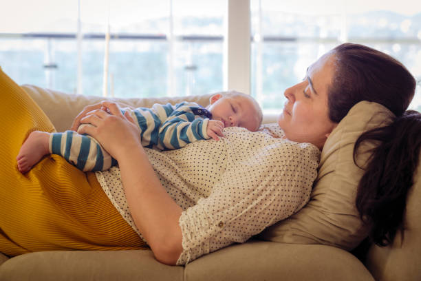 istock Baby playing with mother on sofa 1296863964