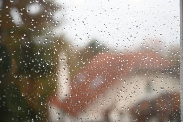 istock Water drops on a window with a house in the background 1296864866