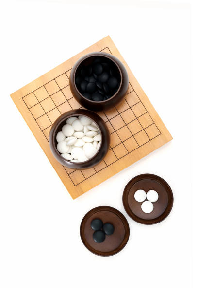 istock Go game stones in wooden bowls isolated on white 1296866238