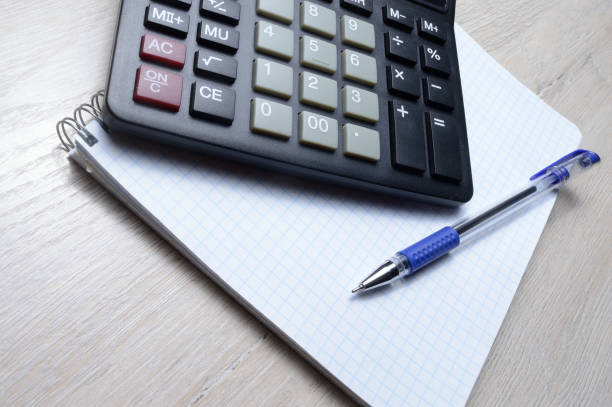 istock a ballpoint pen and a micro calculator lie on a squared notebook. close-up. 1296866813