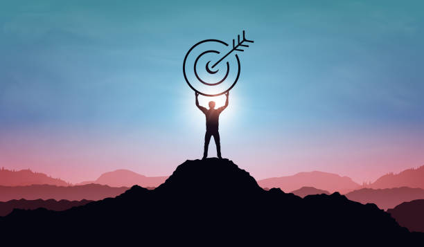 Targeting the business goal and achievement success concept. Businessman standing on top of mountain and holding target board at sunset background. Vision of businessman towards organization company Targeting the business goal and achievement success concept. Businessman standing on top of mountain and holding target board at sunset background. Vision of businessman towards organization company flaglets stock illustrations