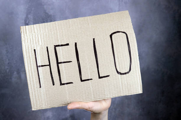 istock hand holds a banner with the inscription Hello 1296872317