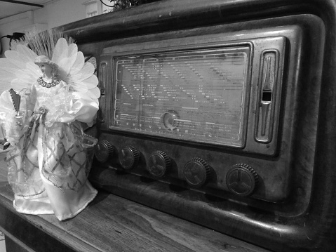 Woman turning volume knob on radio at home, closeup