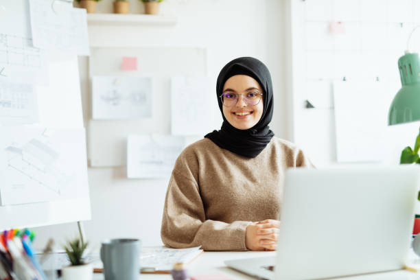 istock Successful Middle Eastern businesswoman working on laptop in office and looking at camera 1296872818