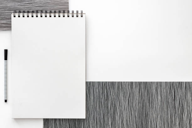 Blank spiral bound sketchbook with empty open page. Top view real photo. White background for text. Copy space. Black and white minimal concept\
