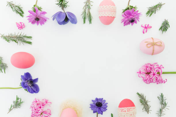 istock Ester frame composition with colorful eggs, spring flowers, hypericum and leaves of lavender on white background. Flat lay, top view 1296875299