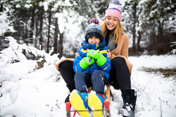 istock Mother and son having fun sledding 1296878412