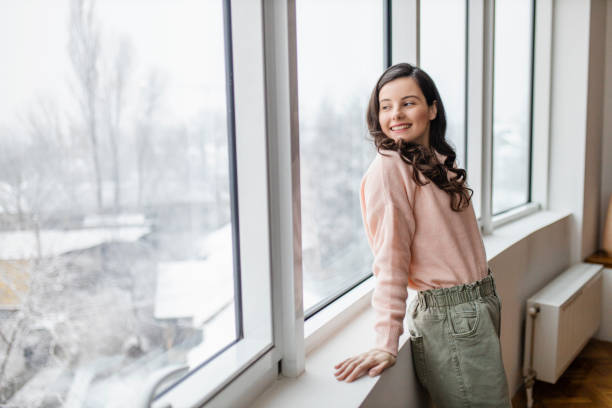 istock Woman resting at home and day dreaming while looking through window 1296878655