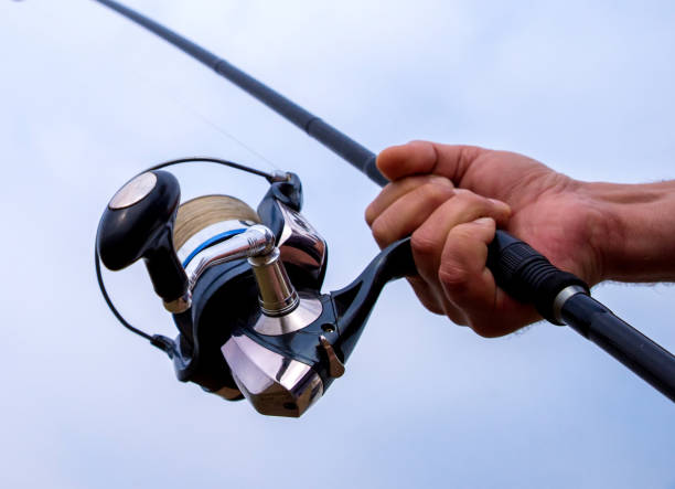 istock Man hand holding fishing rod 1296878743