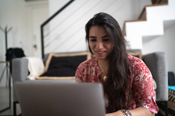 istock Young woman doing a video call using laptop at home 1296880177