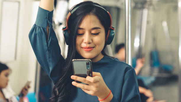 Young woman using mobile phone on public train stock photo