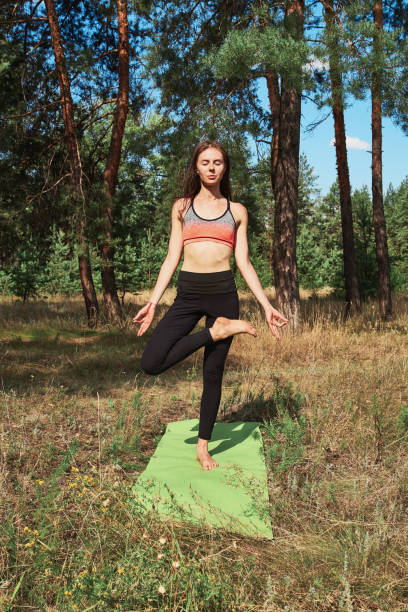 piękna młoda kobieta robi jogę na naturze. - zen like nature breathing exercise sitting zdjęcia i obrazy z banku zdjęć