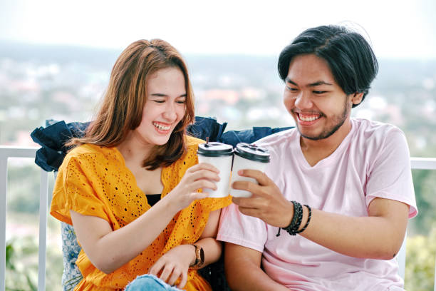 istock Beautiful Couple Drinking Coffee Together at Balcony 1296883813