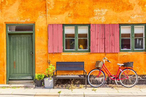 Old yellow house of Nyboder district with a red bicycle. Old Medieval district in Copenhagen, Denmark.