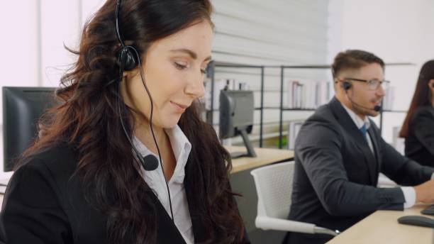 istock Business people wearing headset working in office 1296888312