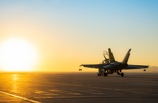 Jet fighter on an aircraft carrier deck against beautiful sunset sky . Elements of this image furnished by NASA . https://nasasearch.nasa.gov/search/images?affiliate=nasa