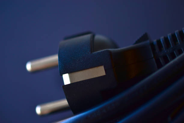 istock Black plug of the computer power cable on a black background 1296890737