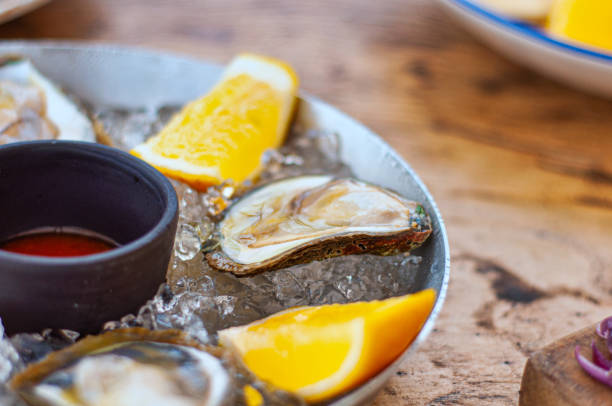 istock Fresh Oysters close-up on metal plate with ice 1296890748