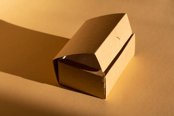 istock brown cardboard box on beige background and its shadow 1296891191