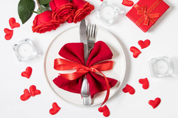 istock Valentine's day romantic dinner concept. Beautiful table setting. Roses and candles on a white background. 1296892640