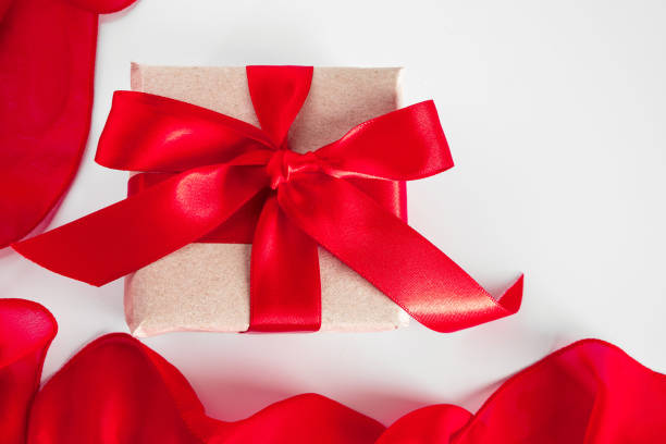 istock Gift box with craft paper and red ribbon on a white background 1296892726