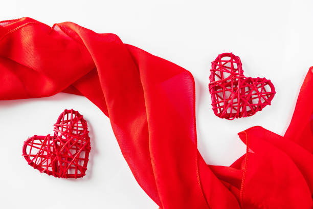 istock Red hearts and silk ribbon on a white background 1296892731