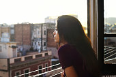 Girl profile in the window at sunset