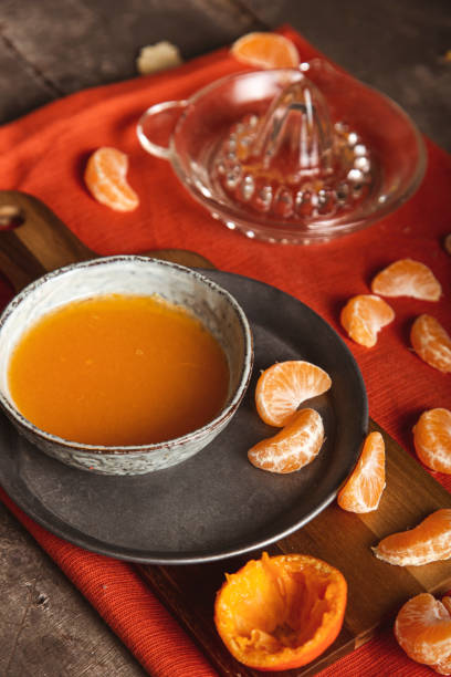 istock Juicy and fresh sliced tangerine with juice on cutting board, table top view. 1296893655