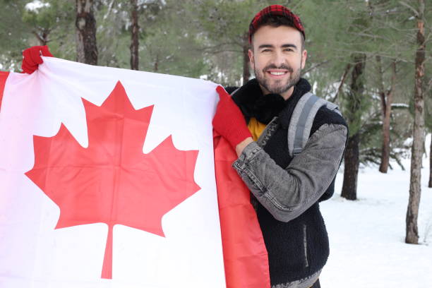 istock Canadian man holding his flag in snow background 1296894203