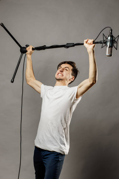 istock Caucasian man holding a microphone. Studio shout 1296894903