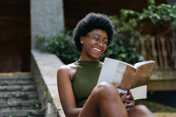 istock Woman reading a book in her backyard 1296896620