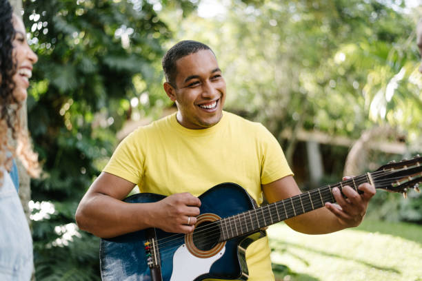 istock Friends playing guitar outdoors 1296896677