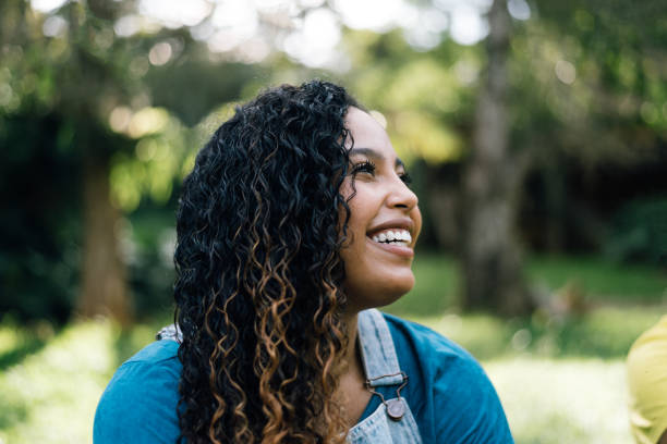 istock Smiling young woman in public park 1296896720