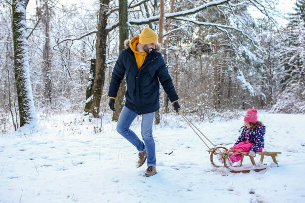 istock Father and daughter sledding on a snowy winter day 1296897754