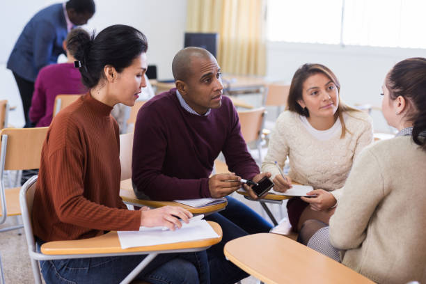 istock Adult students in cooperation with their school assignment 1296898294