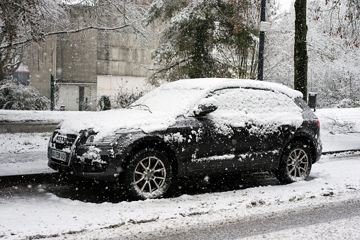 Close up of a car with side view mirror fully covered in snow during winter