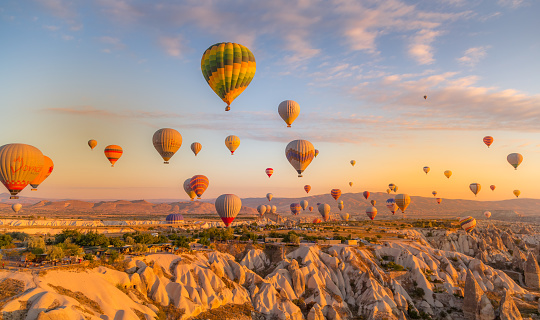 Cappadocia, Turkey - October 07 2019 - Stunning morning view of the many tourist balloons in Cappadocia taking off at sunrise.