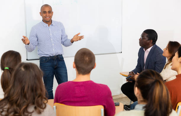 istock Hispanic lecturer is pointing something on board to his students 1296899040