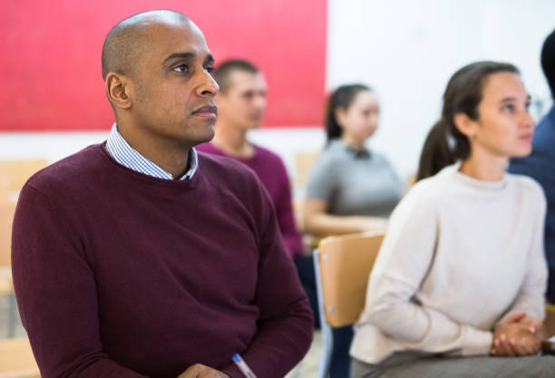 istock Group of students attentively listening to lecture in classroom 1296899092