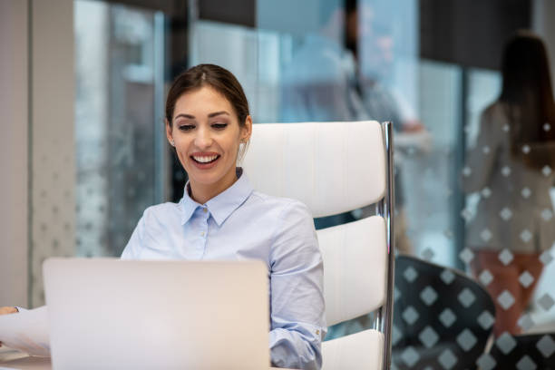 istock Young woman is sitting at the office, using her laptop. 1296899455