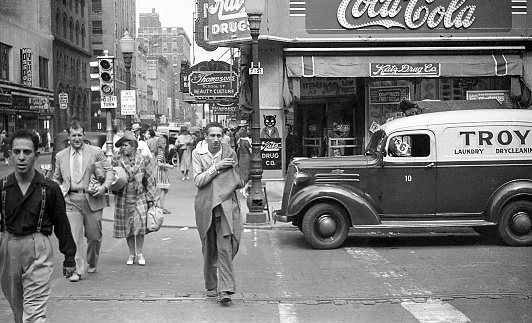 Downtown street scene with people and cars on street at 7th and Locust, Des Moines, Iowa, USA, 1939 including Katz Drug Store in the Edna Griffin Building. In 1948, ten years after this photo, the Katz Drug Store would be the scene of a civil rights incident when Edna Griffin, an African American, and her family were refused service.