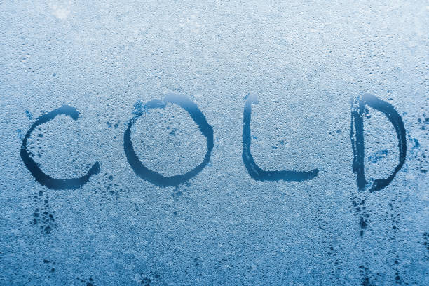 istock The inscription cold on the frozen window with patterns 1296901680