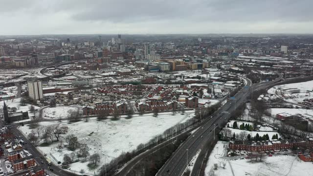 Aerial footage of the town centre of Leeds in West Yorkshire, near the Bridgewater Place apartment building along side the Leeds Train Station in the snow and winter time