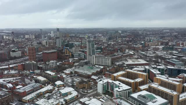 Aerial footage of the town centre of Leeds in West Yorkshire, near the Bridgewater Place apartment building along side the Leeds Train Station in the snow and winter time